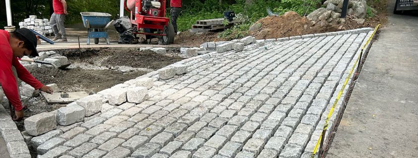 Workers laying stone pathway in forest setting