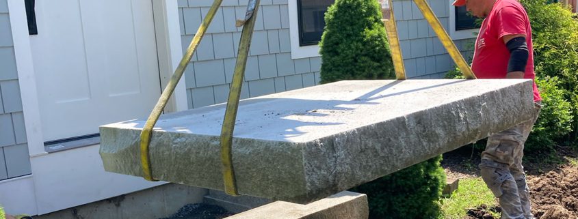 Worker securing a large stone slab