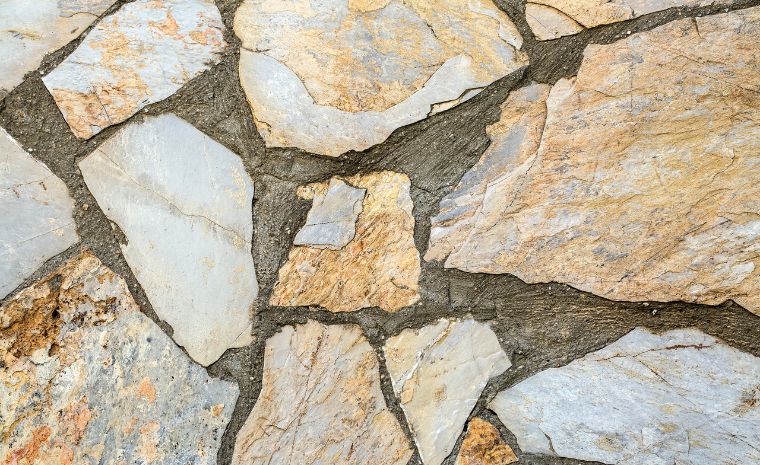 A stone retaining wall in Westport, CT, displaying an array of colors and shapes, highlighting its robust and durable design.