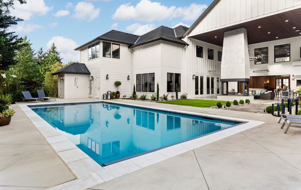 Elegant white house with a pool, highlighting the craftsmanship of a Mason Contractor in Madison, CT.