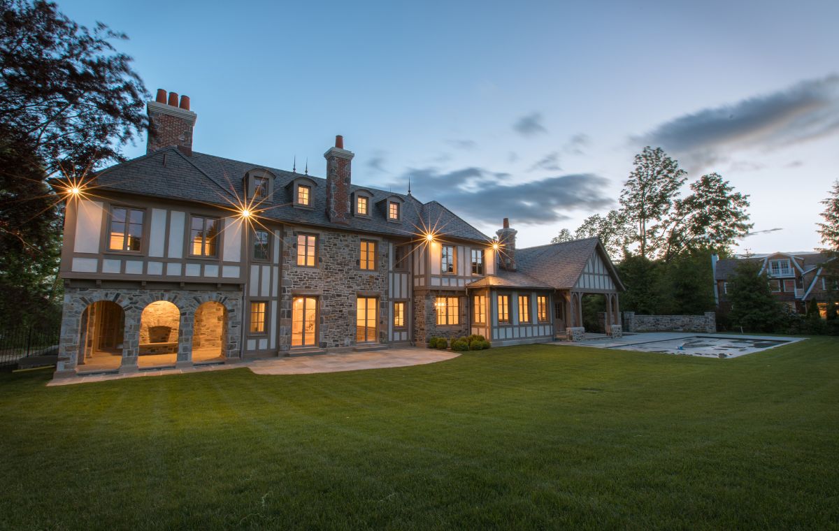 Exterior view of a spacious home featuring a pool and lawn, highlighting a Mason Contractor's project in Madison, CT.