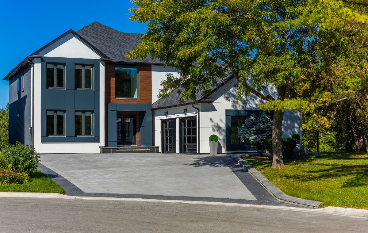 A large home with a driveway and garage, showcasing driveway edging by a Mason Contractor in Madison, CT.