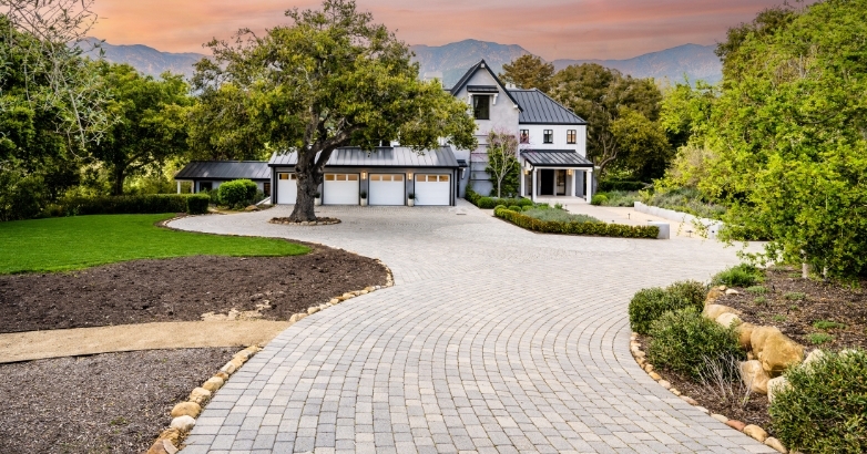 A driveway featuring a brick path leading to a house, illustrating the visual appeal of stamped concrete.