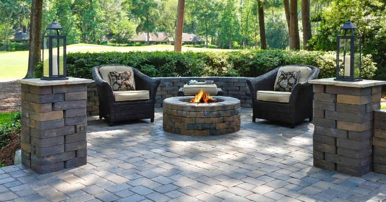A brick patio featuring a fire pit surrounded by chairs, illustrating the importance of choosing the right stone for patios.