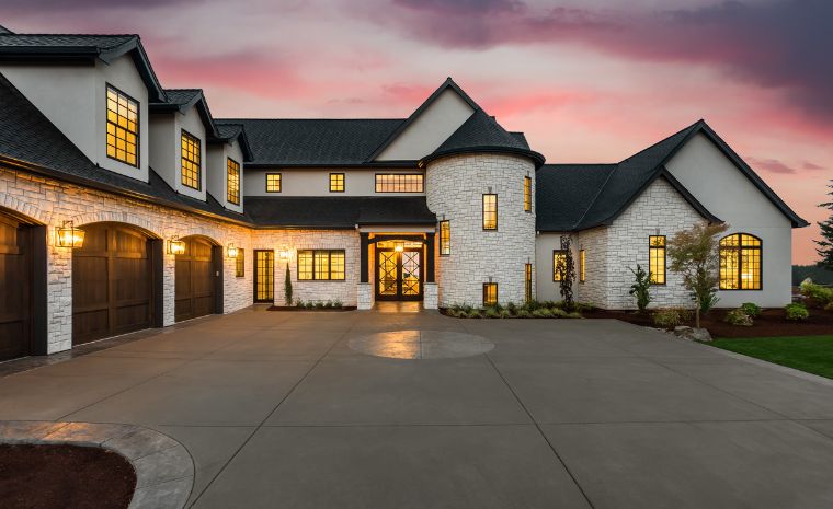 A beautiful home featuring a driveway and garage, showcasing masonry work by a construction company in Chester, CT.