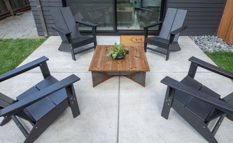 A patio featuring four chairs and a table, designed by a masonry construction company in Stonington, CT.