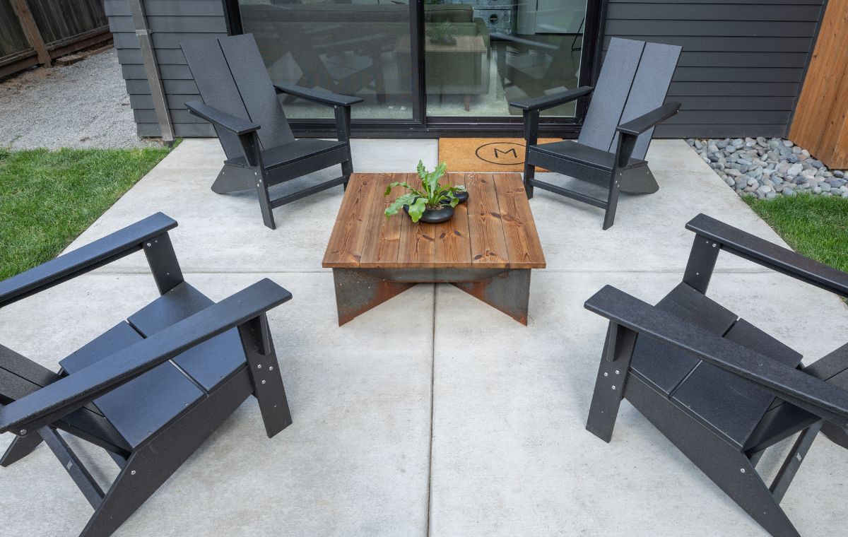 A backyard patio featuring four chairs arranged around a table, designed by a contractor in Chester, CT.