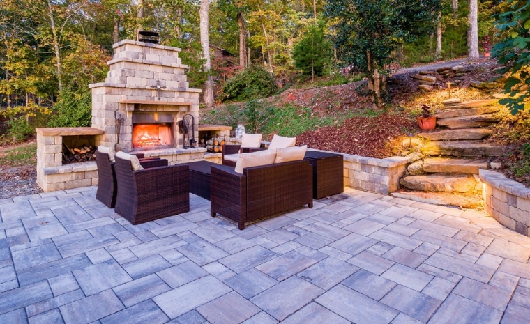 A backyard patio featuring a stone fireplace and comfortable seating area, designed by a contractor in Guilford, CT.