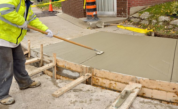 A man uses a tool for concrete residential sidewalk project in Greenwich, CT.
