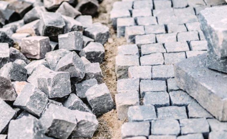 A collection of gray and black stones on the ground, designed for driveway edging in Mystic, CT, showcasing durable materials.