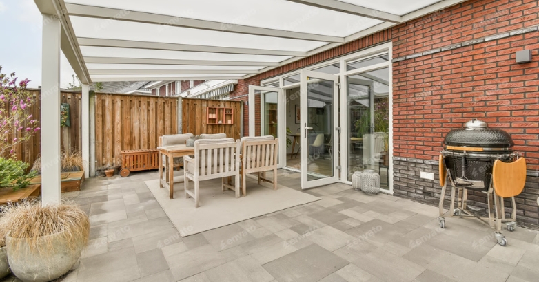 A luxury patio featuring a grill and dining table, with retractable screens for added comfort and style.