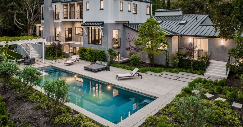 A modern home featuring a luxurious pool and stylish patio, showcasing resort-style outdoor living ideas.