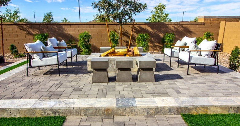 A Mediterranean-style stone patio featuring a cozy fire pit and comfortable seating area for relaxation.