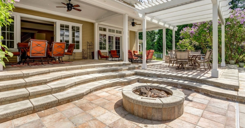 A stone patio featuring a cozy fire pit surrounded by a comfortable seating area, ideal for outdoor gatherings.