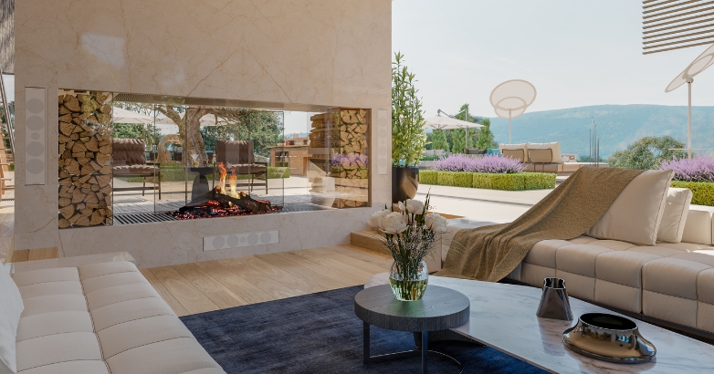A cozy living room featuring a double-sided fireplace and a scenic view of the mountains through large windows.