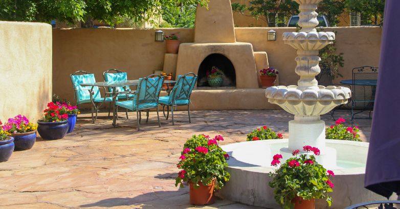Natural stone patio with fountain, outdoor fireplace, and dining set—showcasing durability and timeless design