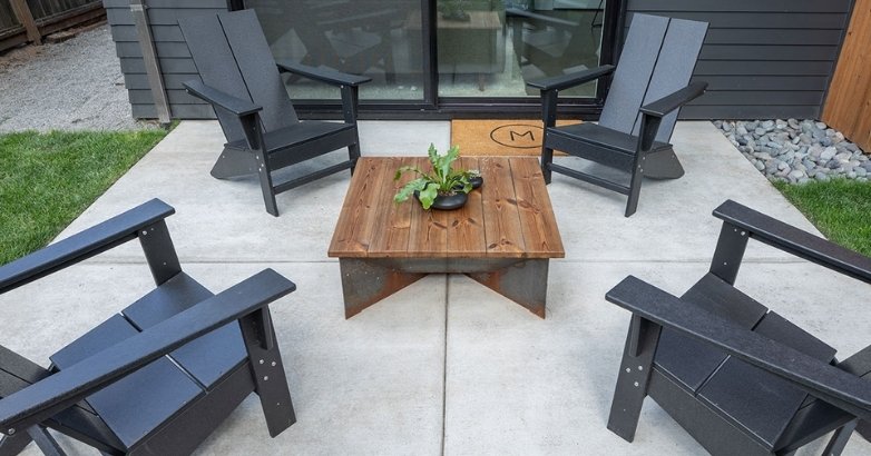 An outdoor patio with four chairs and a table, providing a cozy space for relaxation in Connecticut's climate.