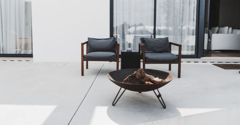 Modern concrete patio with fire pit and seating area showing clean slab design and low-maintenance surface.