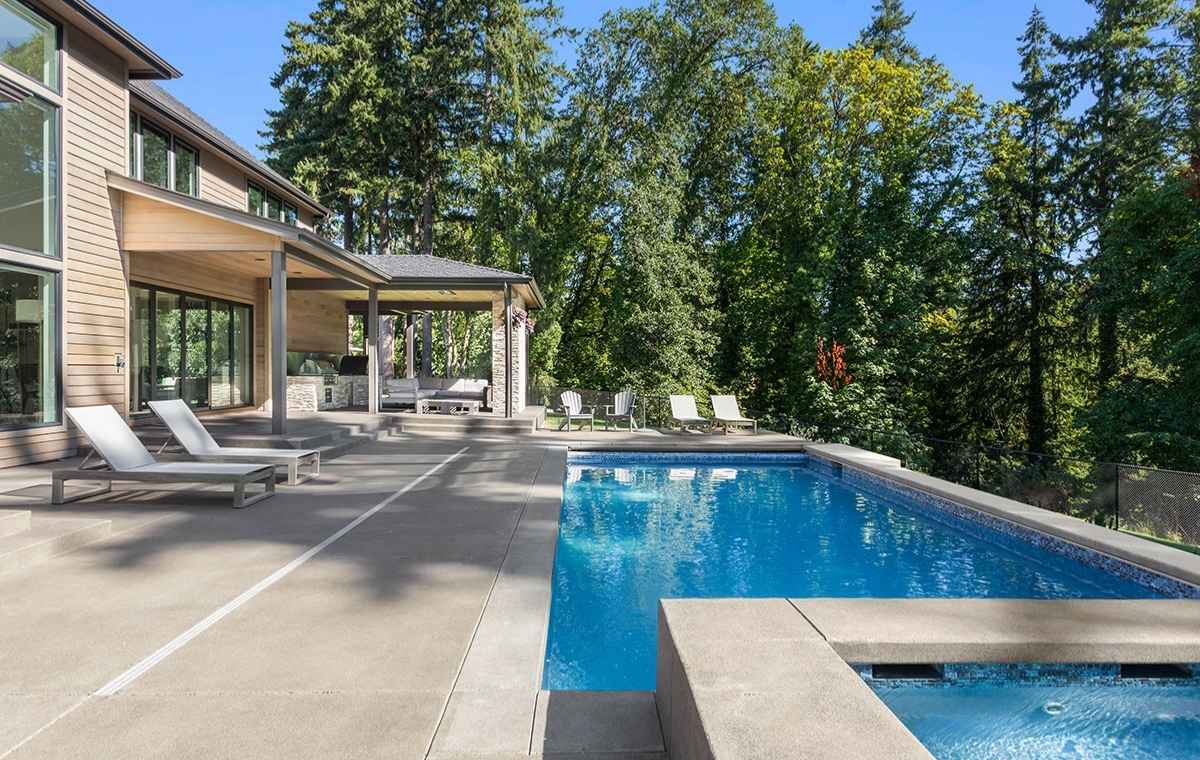 A luxurious pool in a modern home, featuring a stone deck and patio for an elegant outdoor experience.