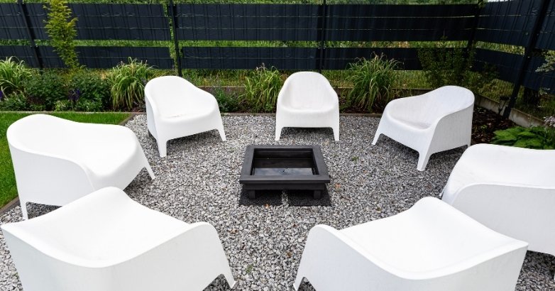 Gravel patio with fire pit and seating area for low-maintenance outdoor space