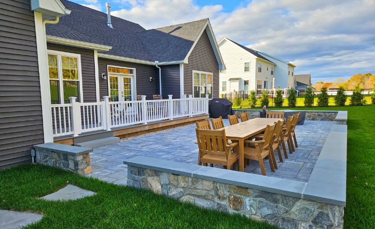 Expert stone patio installation with seating wall and dining area in Madison CT