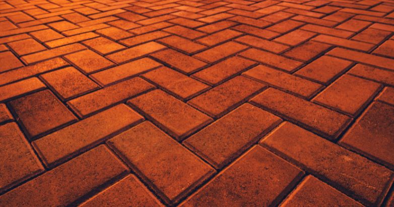 A close-up image of SW-grade brick pavers arranged in a herringbone pattern