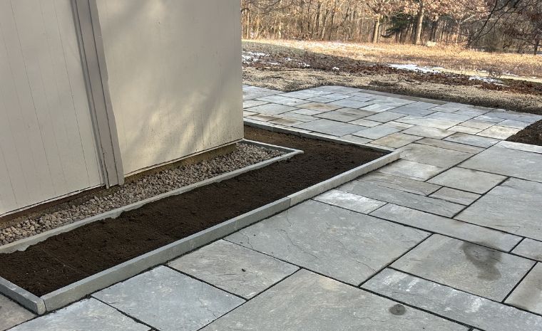 Bluestone patio installation in Guilford, CT and walkway with stone edging and prepared garden beds