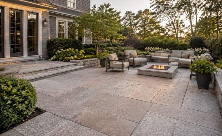 Granite stone patio with fire pit and lounge seating at an Essex CT home